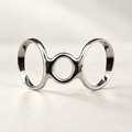 Boutonniere finger splint in polished silver-tone metal with two large open loops and a smaller center loop, studio view
