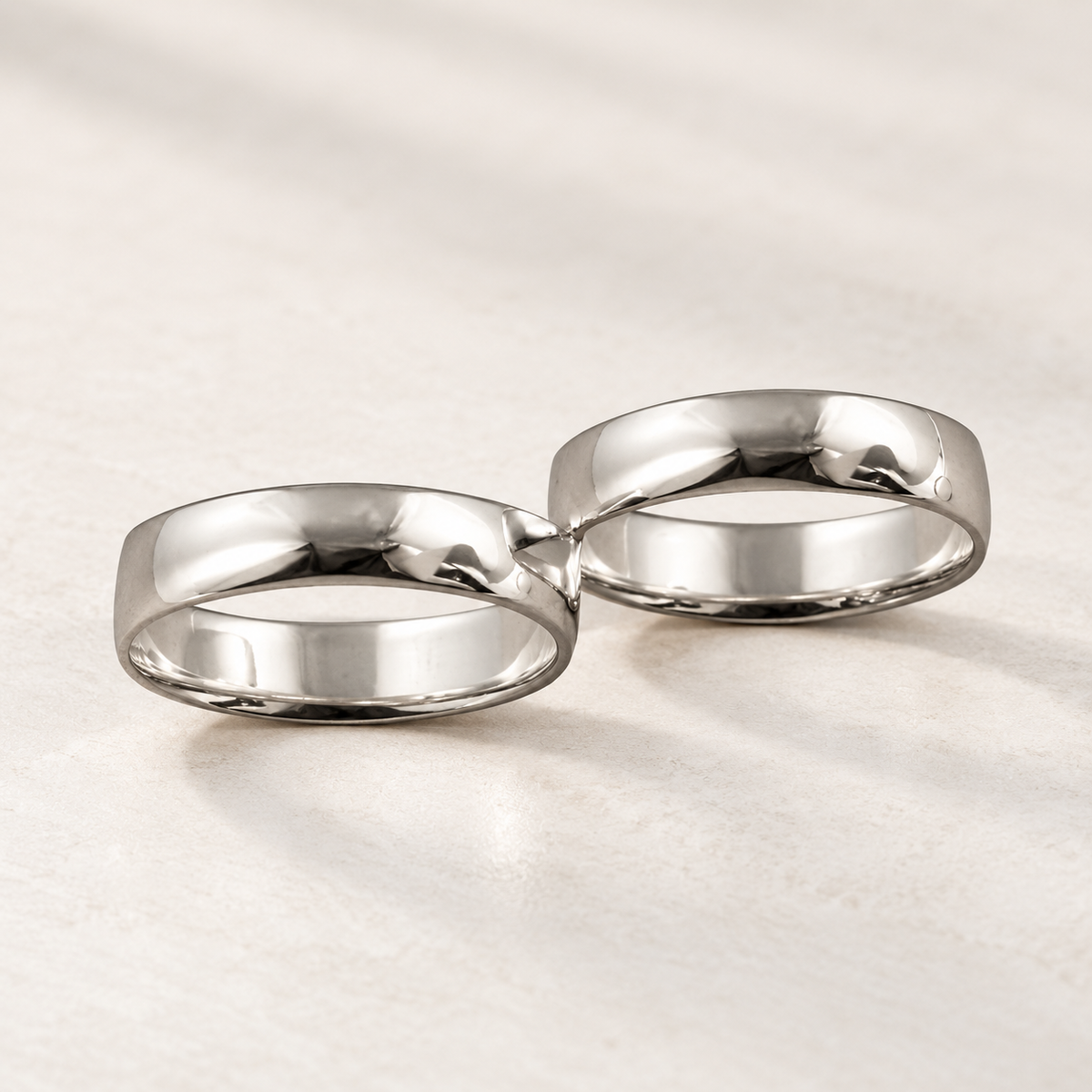 Buddy ring in polished silver-tone metal made of two connected bands, studio view