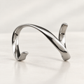 Spiral splint in polished silver-tone metal with a continuous twisting form, studio view