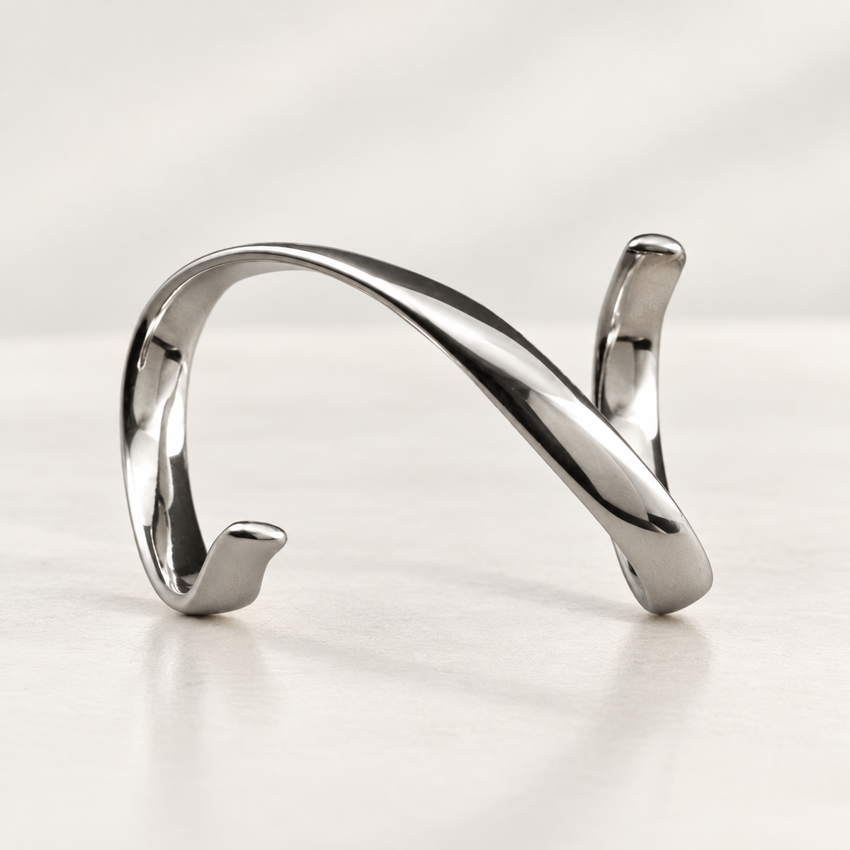 Spiral splint in polished silver-tone metal with a continuous twisting form, studio view