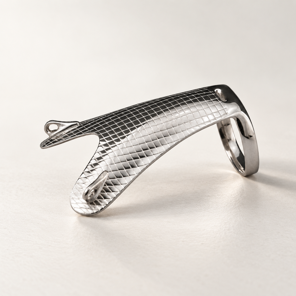 Stable thumb splint in polished silver-tone metal with a textured grid plate, thumb ring and bracelet attachment points, studio view