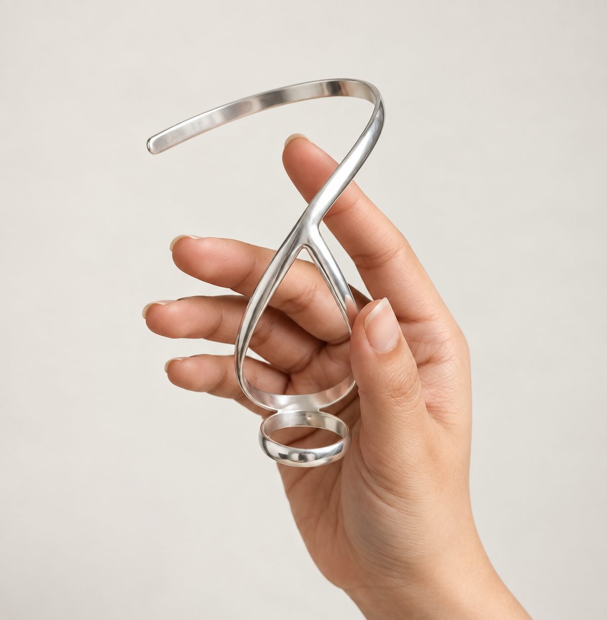 Thumb ring splint with wrist bracelet held in the hand to show its shape